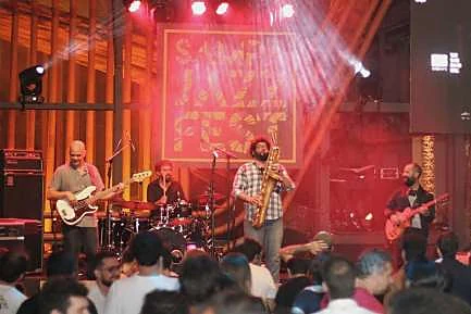 Banda tocando sob luz quente de palco